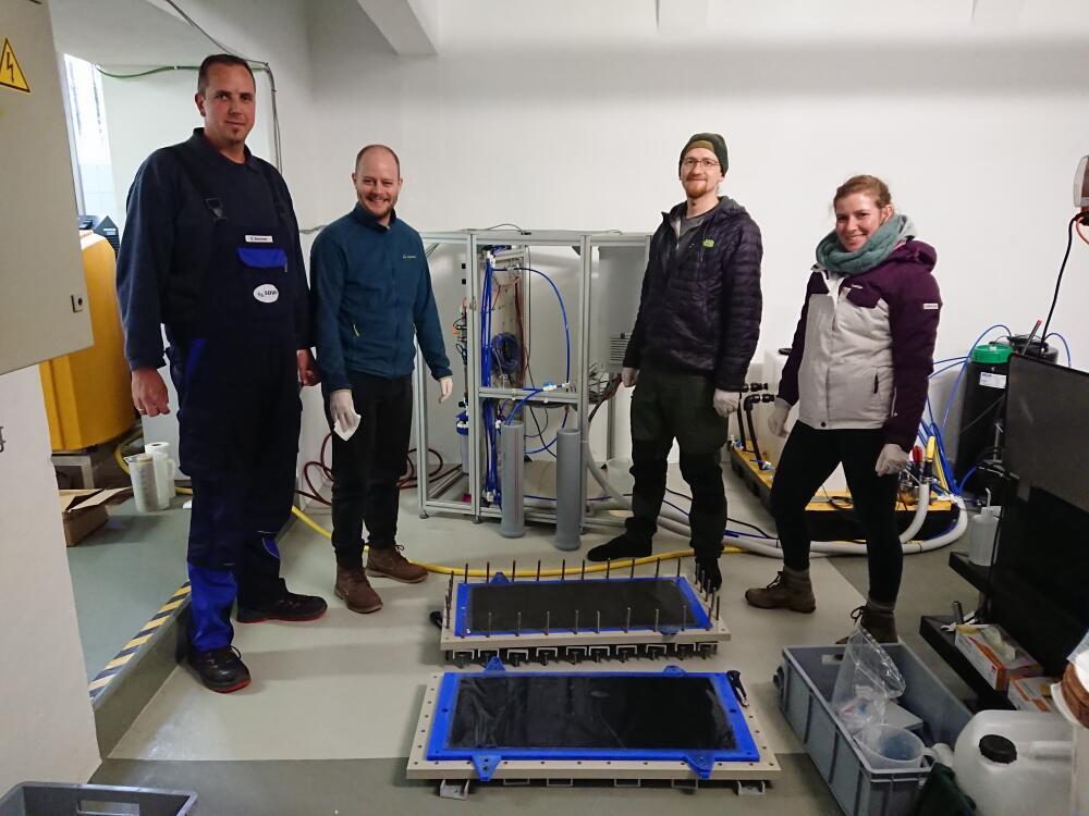 Partners of the innovatION project stand infront of the modified pilot plant on Langeoog